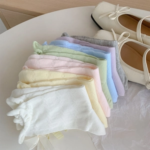 Close-up of pastel mesh knit socks with bow details and elegant Mary Jane shoes