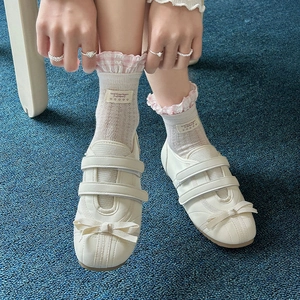 Détail de baskets Mary Jane blanches avec nœuds en soie et chaussettes à carreaux