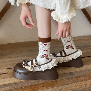 Detail of white crew socks with cherry bow patterns and lace trim Mary Jane shoes