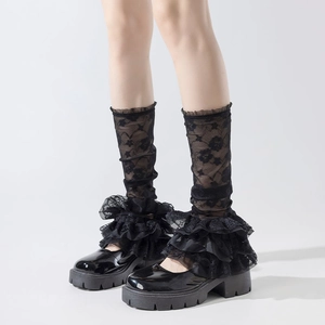 Close-up of black lace leg warmers with floral patterns and layered ruffles for Lolita style