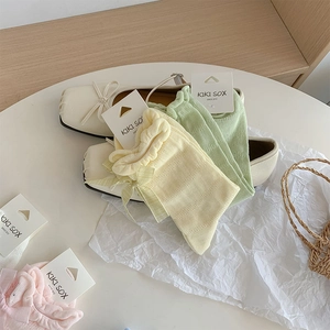 Detailed view of pastel mesh socks with ribbon bows and ruffle edges in various colors