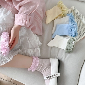 Détail de chaussettes mi-hautes côtelées pour femmes avec bordure à volants et coton doux