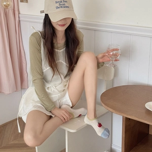 Detail of white striped ankle socks with apple motif and blue toe for a casual summer look