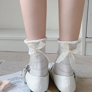Detail of white hollow mesh socks with silk bow on heel and wavy ruffled edge cuffs