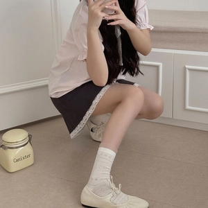 Détail de chaussettes à fleurs en dentelle blanche avec babies beige et chemise rose