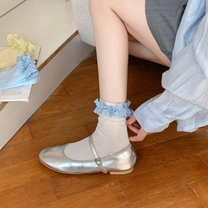 Détail de chaussettes côtelées blanches avec dentelle bleue et chaussures Mary Jane