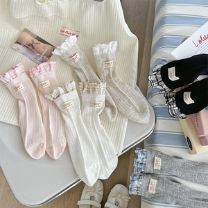 Détail de bordures en dentelle et étiquettes tissées sur chaussettes mi-hautes