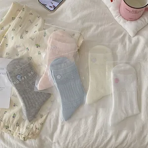 Détail de 5 paires de chaussettes pastel à côtes avec dentelle et boutons de fleurs