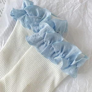 Détail de chaussettes en coton blanc avec bordures délicates en dentelle bleu clair