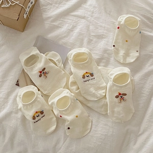 Close-up of beige low-cut cotton sock with dog embroidery and colorful polka dots