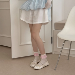 Detail of white girl's socks with pink velvet ruffle trim and delicate vertical stripes