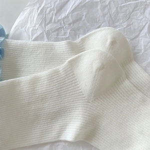 Détail de chaussettes blanches à côtes avec bord volanté bleu et texture verticale