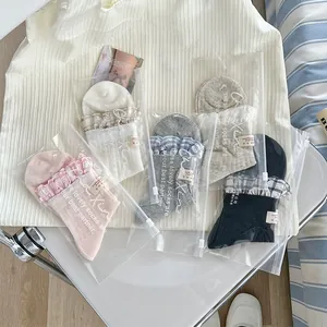 Détail d'un lot de cinq chaussettes à carreaux avec dentelle et pochette zippée