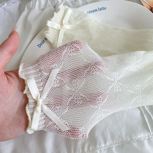 Detailed view of white lace Lolita socks with mesh texture and satin bow decorations