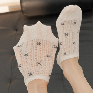 Close-up of thin beige mesh invisible socks with small dark bow pattern detail
