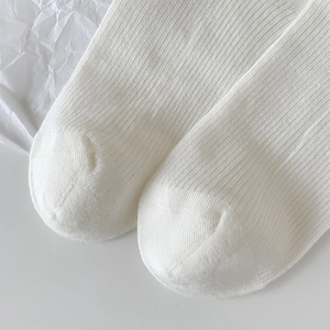 Gros plan de chaussettes blanches côtelées style ballet montrant la maille fine