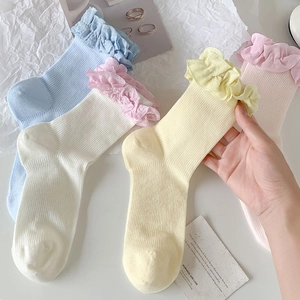 Détails de chaussettes en maille côtelée avec bordure en dentelle ondulée en tons pastel doux