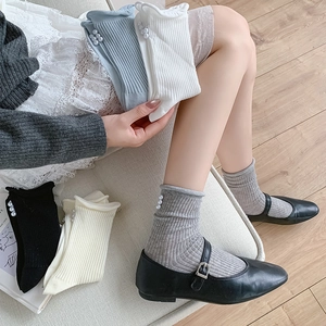 Detail of ballet style calf socks with side pearl buttons and vertical ribbed texture