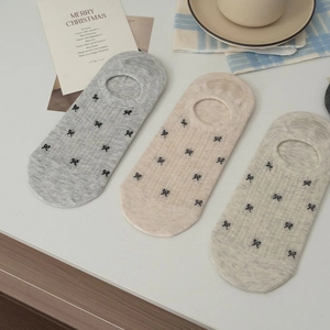 Detailed view of low-cut invisible liner socks with bow patterns in three soft colors