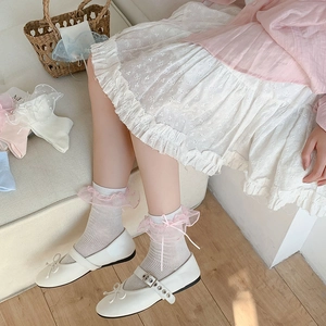 Dettaglio di scarpe Mary Jane bianche con fiocco e calze con bordo in pizzo rosa
