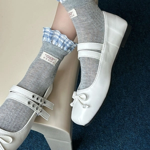 Gros plan de chaussures Mary Jane blanches à nœuds et chaussettes à volants bleu ciel