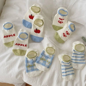 Flat lay of striped and patterned low-cut invisible socks in blue, green, and white colors