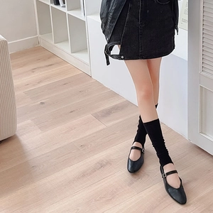 Detail of black Mary Jane flats with stirrup leg warmers and a denim skirt outfit