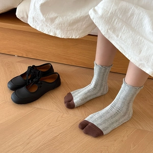 Close-up of ribbed split-toe mid-calf socks in grey and brown color-blocking style