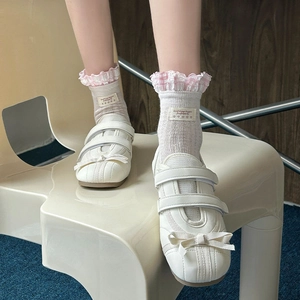 Gros plan de mocassins blancs à nœud et chaussettes à volants à carreaux roses