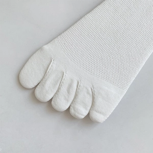 Detail of white five-toe socks featuring breathable mesh knit and individual toe design