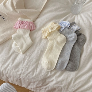 Detailed close-up of four colors ruffle trim socks with ribbed texture in a cozy setting