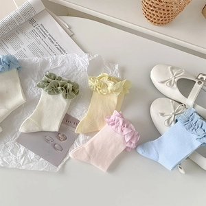 Détail de chaussettes à bordure en dentelle volantée aux couleurs pastel et maille coton