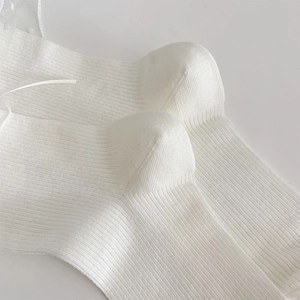 Dettaglio della trama a costine bianche e del tallone ergonomico delle calze stile balletto