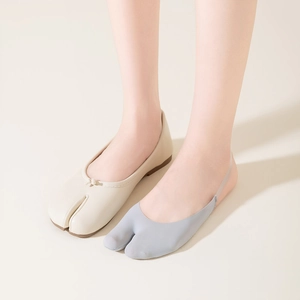 Détail de chaussettes tabi portées avec des ballerines beiges à nœud décoratif élégant