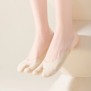 Gros plan de chaussettes beiges à bout fendu avec sangles de talon en silicone antidérapantes