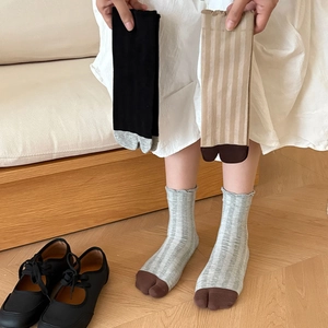 Detail showing ribbed knit Tabi socks with split-toe design and scalloped edges