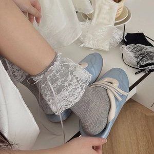 Détail de chaussettes grises à dentelle et rubans avec des Mary Jane bleues