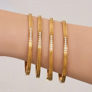 Close-up of elegant 18K gold plated rectangular zircon studded bangles on wrist
