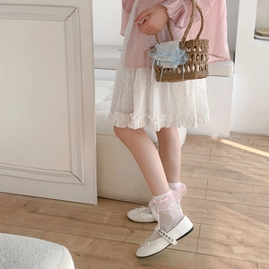 Dettaglio di calzini in pizzo rosa abbinati a scarpe Mary Jane bianche stile giapponese