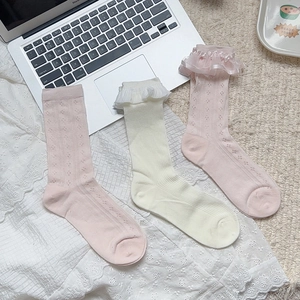 Detail of lace trim and ruffled bow on pink and beige hollow mesh breathable socks