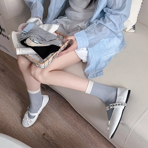 Close-up of cotton mesh crew socks in neutral tones styled with Mary Jane shoes