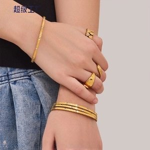 Detailed close-up of a stacked gold ring set featuring heart patterns and smooth bands