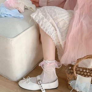 Dettaglio calzini in cotone grigio chiaro con pizzo rosa e fiocchi di nastro con scarpe