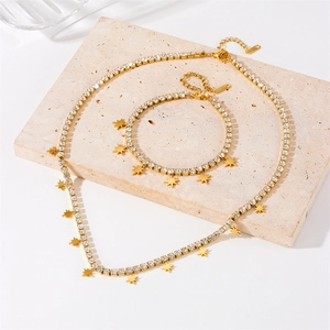 Detailed close-up of gold star charms and white rhinestones on tennis chain jewelry set