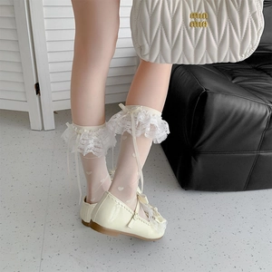Detail of white lace trim socks featuring delicate ribbon bows and heart jacquard patterns
