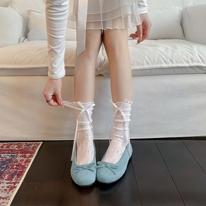 Gros plan de chaussettes en dentelle blanche avec nœuds et ballerines bleu clair