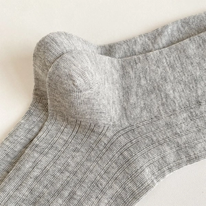 Close-up of grey ribbed cotton socks showing detailed heel construction and knit texture