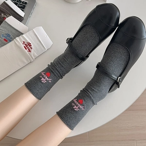 Close-up of letter and heart embroidery on ribbed cuffs of cotton crew socks