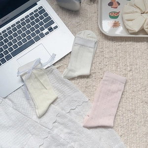 Three pairs of lace-trimmed mesh socks with bows and floral knit in soft pastel tones