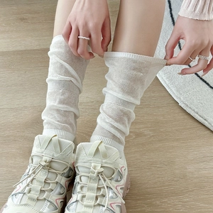 Close-up of white breathable mesh slouch socks paired with sneakers for a ballet-core look